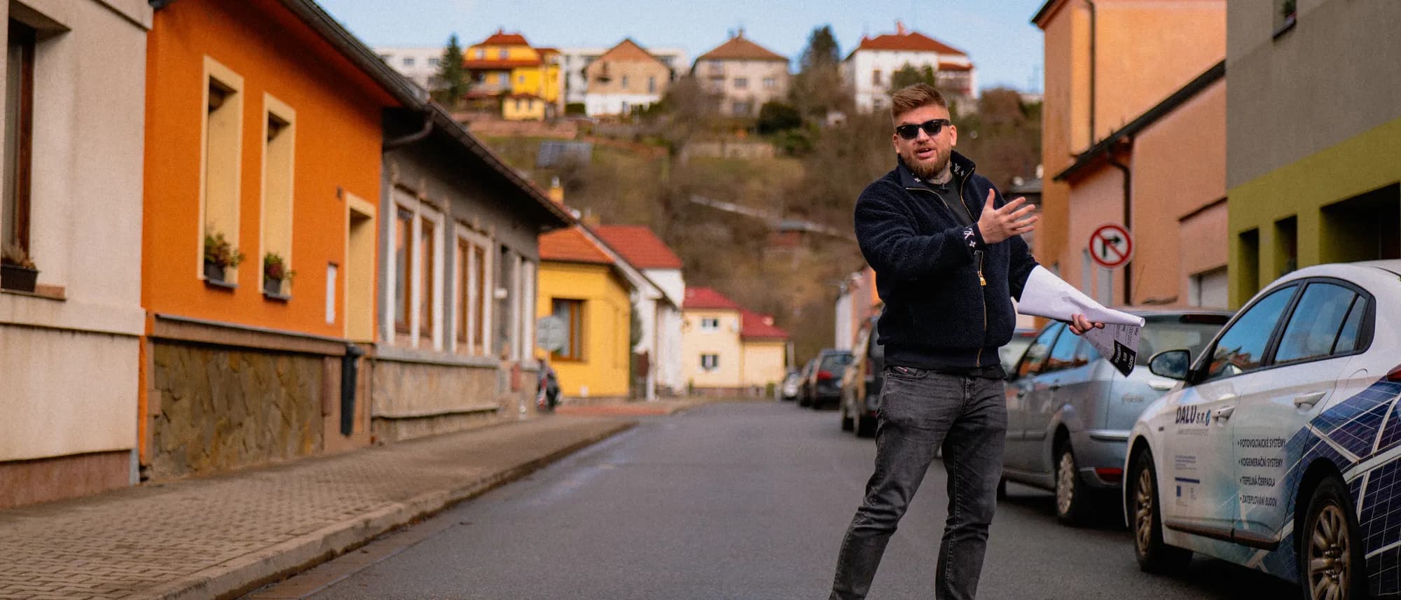 Maxim Ponomarenko z planem nieruchomości w ręce na ulicy domów jednorodzinnych