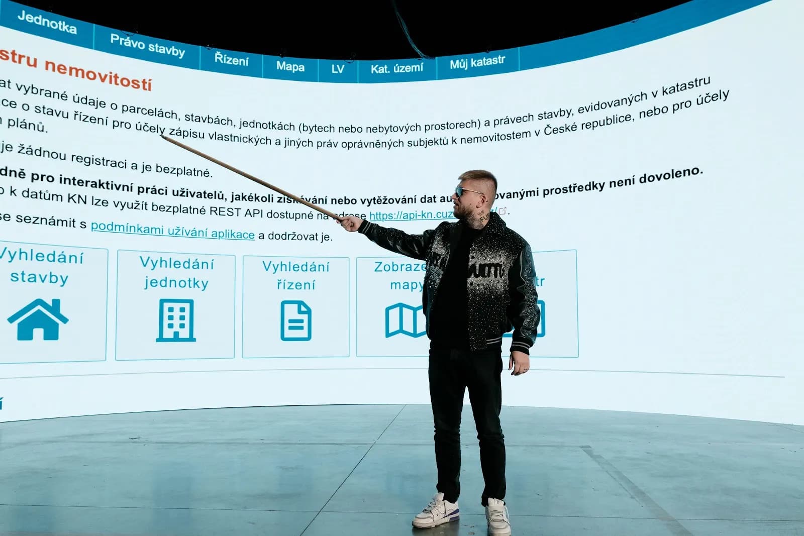 Maxim Ponomarenko pointing at the Land Registry search projected on a large screen