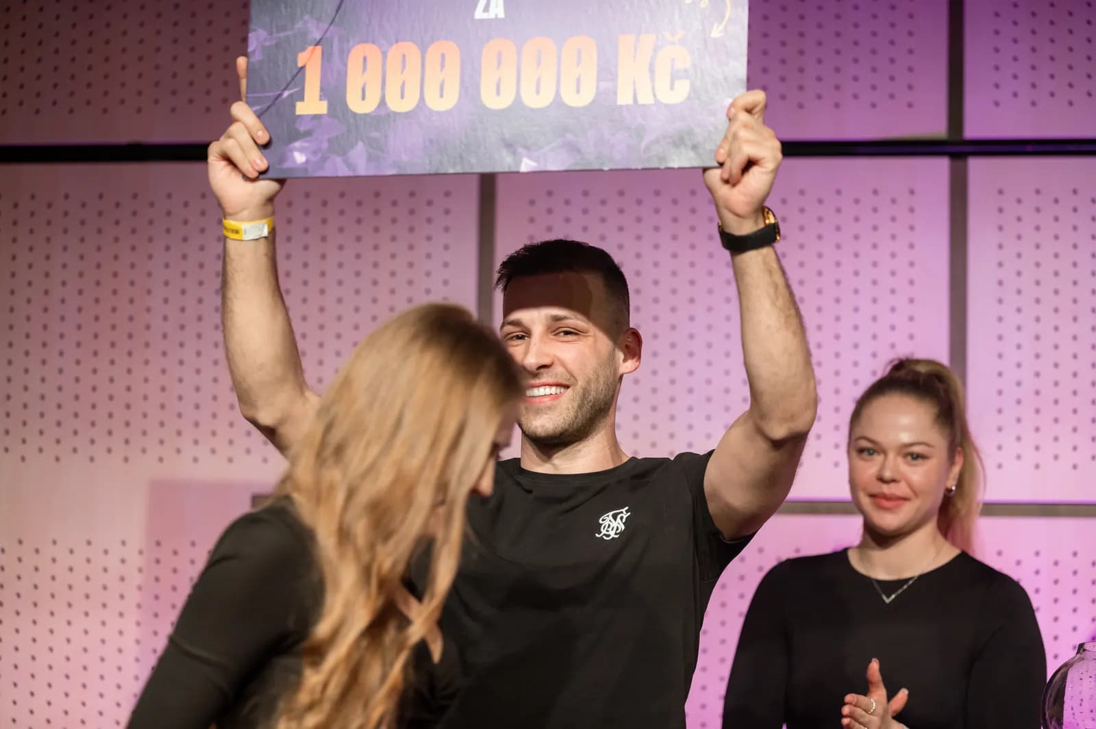 Победитель поднимает над головой чек на 1 000 000 Kč