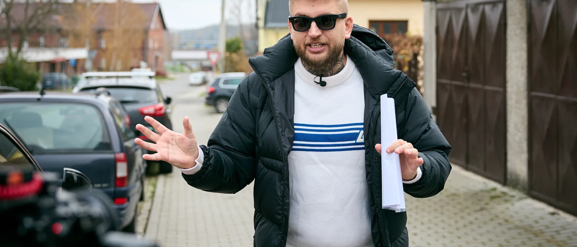 Maxim Ponomarenko z planem nieruchomości w ręce na ulicy domów jednorodzinnych