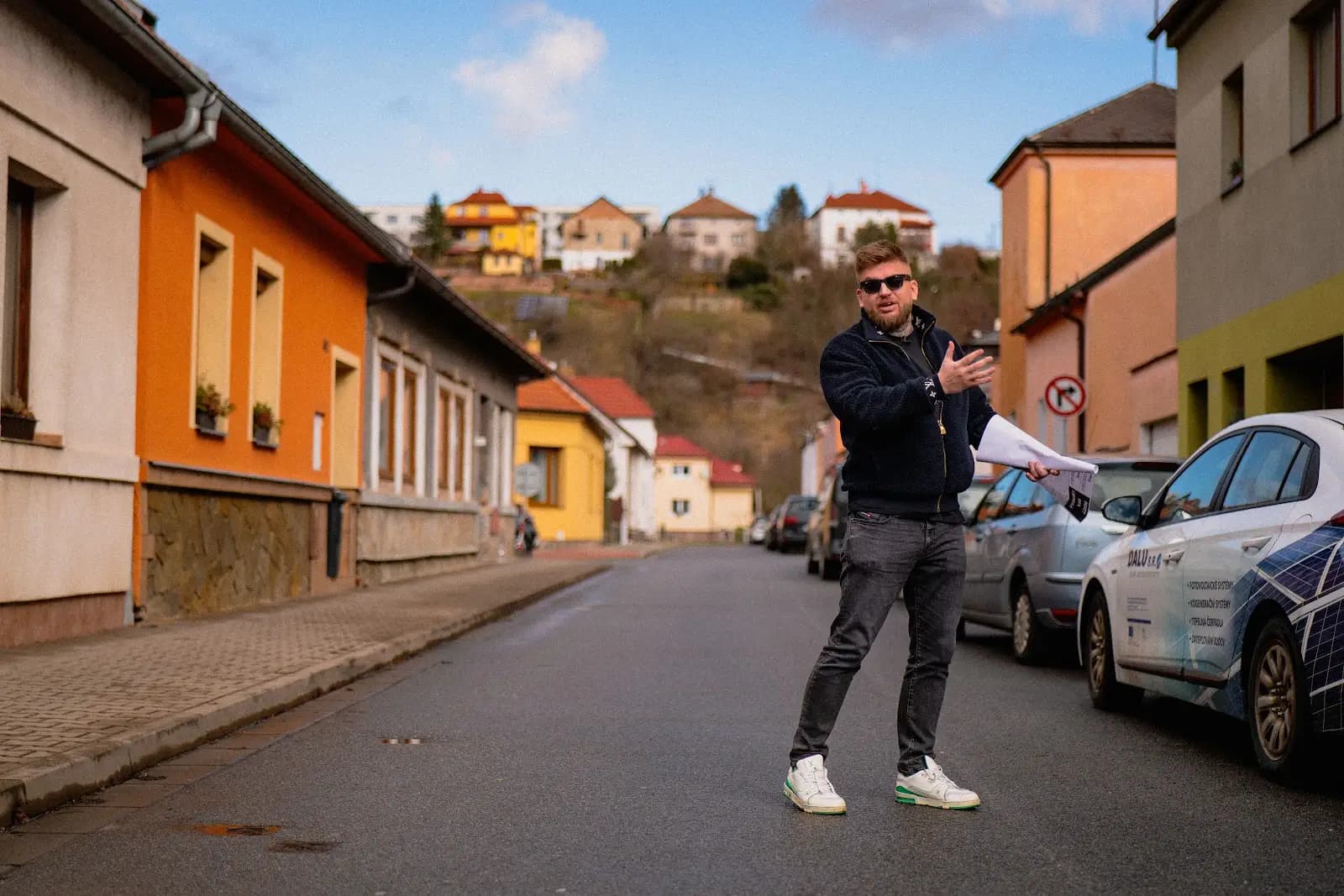 Maxim Ponomarenko en una calle de casas adosadas con la documentación de un inmueble en la mano